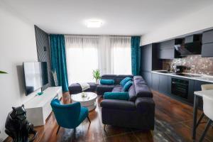 a living room with a couch and blue chairs at Blu Petrolio Stay-Karabas Apartments-parcheggio in Vicenza
