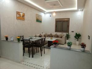 a living room with a table and a couch at Riad Bollywood Spacious 5 Beds Stay in Benguerir