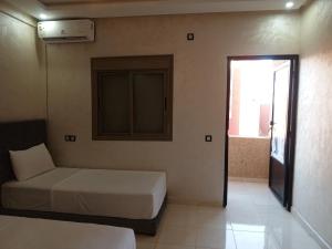 a bedroom with a bed and a window and a door at Riad Bollywood Spacious 5 Beds Stay in Benguerir +3 photos