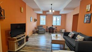 ein Wohnzimmer mit Sofa und Fernseher in der Unterkunft Уютно Централно Студио Враца in Vratsa