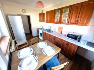a kitchen with a wooden table with plates on it at Dom u Tosi pod Zatorem in Spytkowice