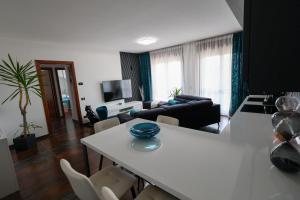 a living room with a white table and a couch at Blu Petrolio Stay-Karabas Apartments-parcheggio in Vicenza