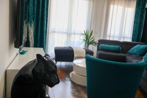 a living room with a couch and a dog statue at Blu Petrolio Stay-Karabas Apartments-parcheggio in Vicenza