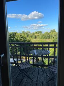 a table and chairs on a deck with a view at gîte chêne doré in Ribérac +8 photos