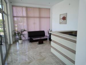 a living room with a black chair and a window at Family Hotel PUDEV in Sunny Beach +16 photos