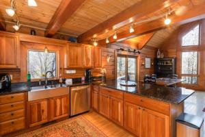 a kitchen with wooden cabinets and a large center island at Stoney Brook Cabin in Boone