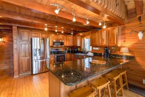a kitchen with wooden cabinets and a granite counter top at Stoney Brook Cabin in Boone +26 photos