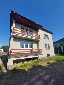 a house with a large bench on the side of it at Dom u Tosi pod Zatorem in Spytkowice
