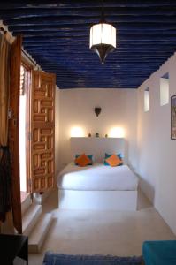a bedroom with a white bed and a blue ceiling at Riad Dar Soufa in Rabat