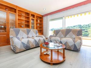 a living room with two chairs and a table at Holiday Home Figaro by Interhome in Blanes +24 photos