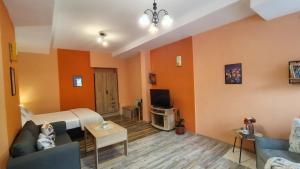 ein Wohnzimmer mit Bett und Fernseher in der Unterkunft Уютно Централно Студио Враца in Vratsa + 18 Fotos