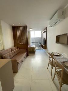 a large living room with a couch and a bed at Porto City - Flat 06 com Jacuzzi in Porto De Galinhas