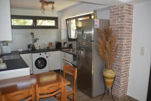 a kitchen with a stainless steel refrigerator and a table at Thalantheia House in Agios Konstantinos