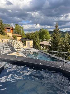 a large pool of water with a metal railing at М House in Vorokhta