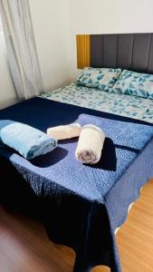 a bed with two towels and two pillows on it at Cond Millenium residênce in Juiz de Fora +11 photos