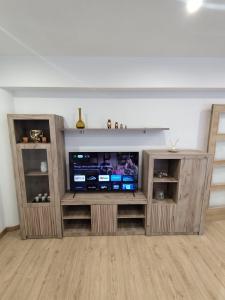 a entertainment center with a television in a living room at Luz De Luna in Negreira