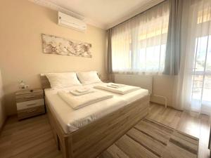 a bedroom with a bed with two towels on it at Molnár Vendégház in Újfehértó