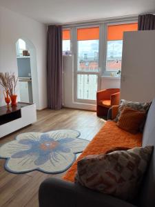 a living room with a couch and a large window at Aleda Kaskada in Szczecin