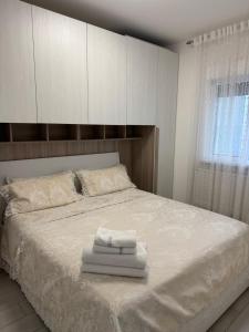 a bedroom with a bed with towels on it at Appartamento Incantevole 300m dal mare in Lignano Sabbiadoro