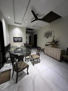 a dining room with a table and chairs and a ceiling fan at brick hotel & luxury suites in Lahore