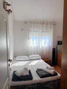 a bedroom with a bed with towels on it at Lumier Apartment in Zelenika