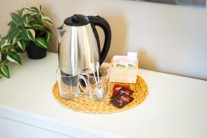 a coffee pot and glasses on a tray on a counter at Hotel Avenida in Vélez-Málaga
