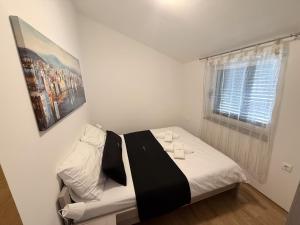 a bedroom with a bed and a window at Apartments Eva in Malinska