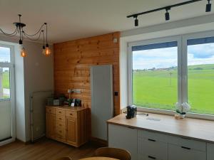 a kitchen with a counter and a large window at Apartament Oravski, blisko Term Chochołowskich, Tatry i Oravice, cisza, widok, parking in Suchá Hora