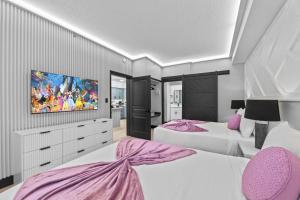 a bedroom with two beds and a tv on the wall at Hawthorn Suites Suite Near Universal & I-Drive in Orlando +3 photos