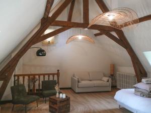 a living room with wooden beams and a couch and chairs at Manoir Du Moulinet in Château-Gontier