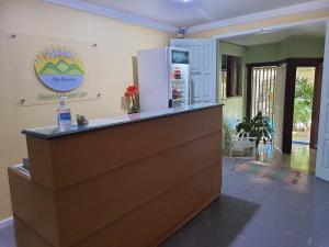 a bar in a room with a counter with a refrigerator at Pousada Alto Riviera in Macaé