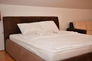 a bed with white sheets and white pillows at SIBE Apartments in Banja Luka