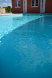 a swimming pool with blue water in front of a house at SIBE Apartments in Banja Luka