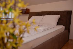 a brown couch with a white pillow and a flower at SIBE Apartments in Banja Luka
