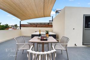 a patio with a table and chairs on a roof at The Jacuzzi Escape in Flic-en-Flac