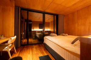 a bedroom with a large bed and a room with a desk at Montefuego - Wellness Villa in Samaipata