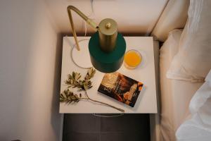 a table with a lamp and a book on a bed at Blue Cyclades Villas in Kastraki +178 photos