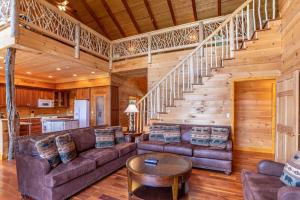 a living room with a couch and a staircase at Sunset View Lodge in Elk Park