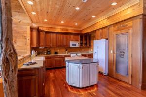a kitchen with wooden cabinets and a white refrigerator at Sunset View Lodge in Elk Park +28 photos