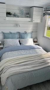 a bedroom with a large bed with striped sheets at Biały domek in Zastań