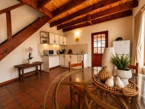 a living room with a glass table and a kitchen at Baviana Beach Lodge - Jacobsbaai - Jacobs Bay in Jacobs Bay