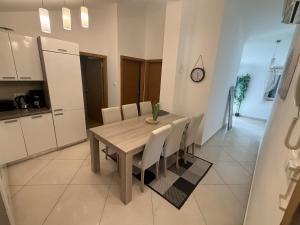 a dining room table and chairs in a kitchen at Apartments Eva in Malinska