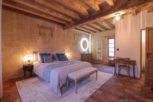 a bedroom with a large bed and a table and chair at RELAI VALDIEU in Courgeon