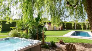 a hot tub in a yard with a tree at RELAI VALDIEU in Courgeon