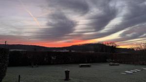 a cloudy sky with a sunset in a field at RELAI VALDIEU in Courgeon +4 photos