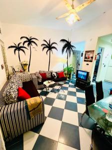 a living room with palm trees and a checkered floor at شاليه in Dawwār Abū Maḩrūs
