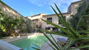 a view of a swimming pool in front of a building at Characterful house with private pool in Paulhan in Paulhan