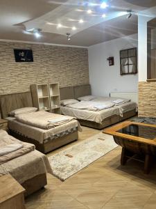 a room with three beds and a table at Apartmani Bjelila in Tivat