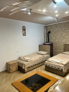 a room with two beds and a table at Apartmani Bjelila in Tivat