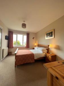 a hotel room with a bed and a window at The Rowans B&B in Connel